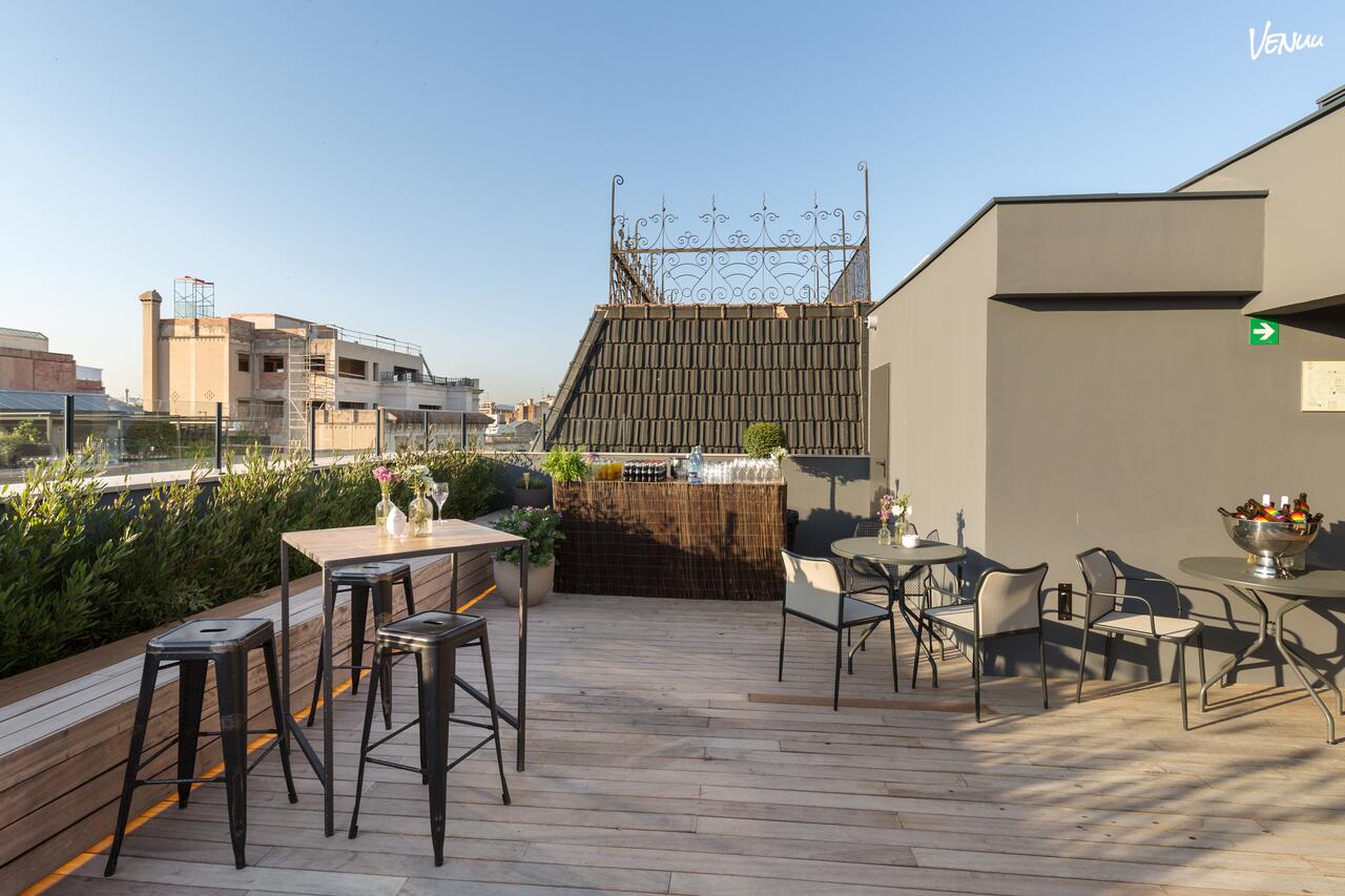  Terraza moderna con piscina y vistas urbanas en Room Mate Gerard, perfecta para cenas con estilo.
