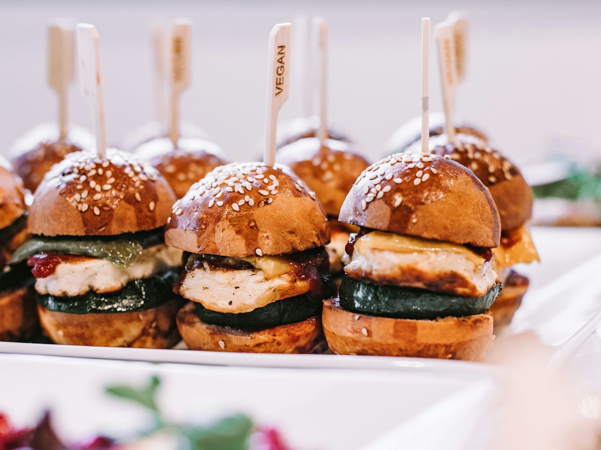 a row of mini sandwiches sitting on top of a white plate