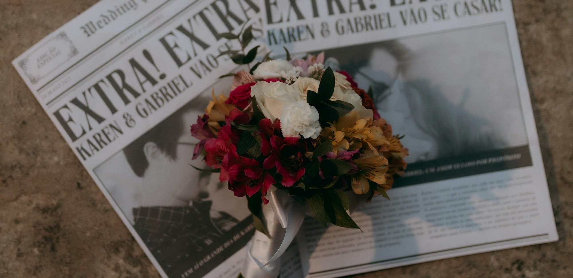 Wedding bouquet rests on newspapers with headlines.